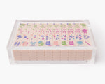 A clear acrylic display box with a removable lid. The acrylic box stores The Mahjong Line mahjong tile set.