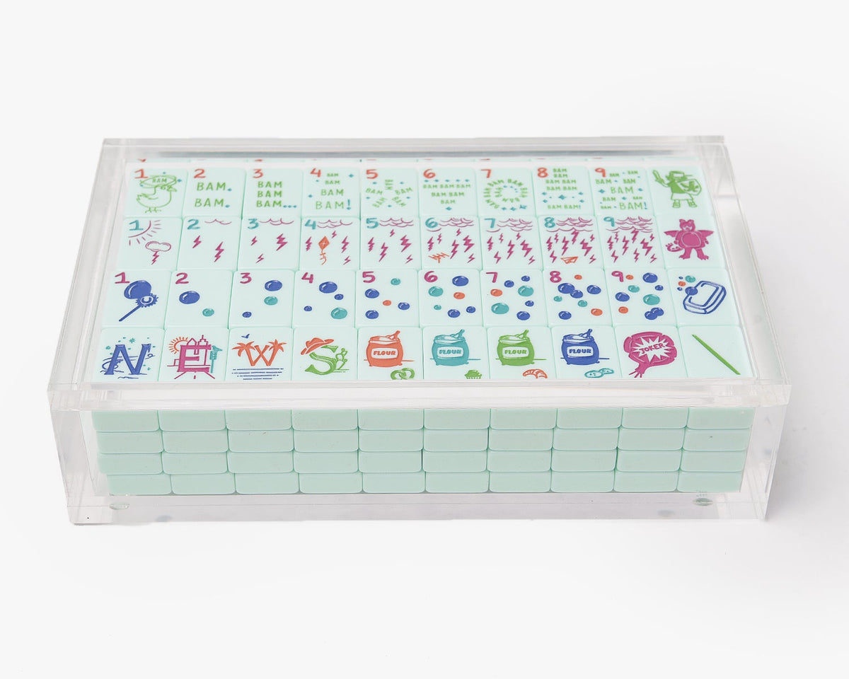 A clear acrylic display box with a removable lid. The acrylic box stores The Mahjong Line mahjong tile set.